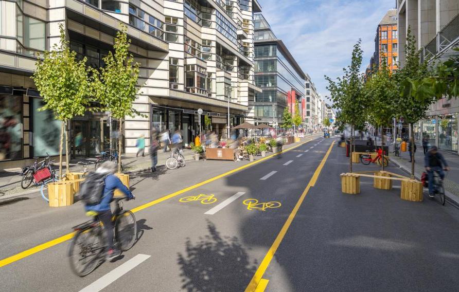 Pop-up bicycle lane in central Berlin with people biking, walking and relaxing. This is a trial concept for urban planning which improves the quality of life of people.